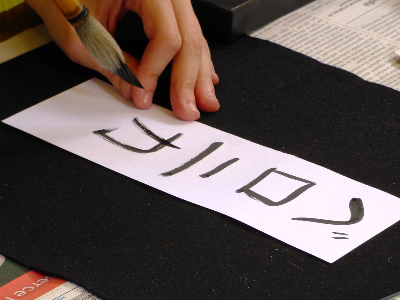 Image montrant des mains faisant de la calligraphie japonaise