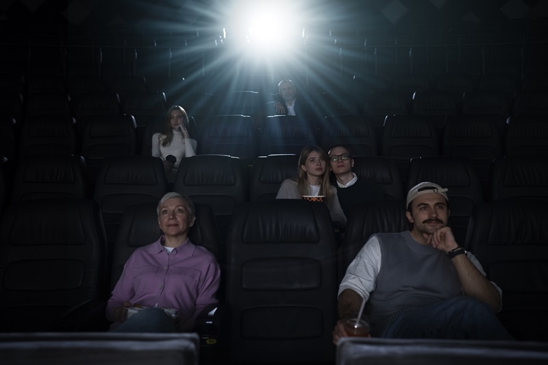 Plusieurs spectateurs regardent un film dans une salle de cinéma