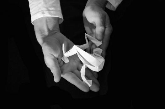 Une grenouille en papier blanc posée au creux d'une main