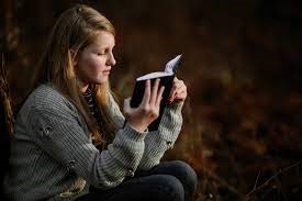 une jeune fille blonde lisant un livre