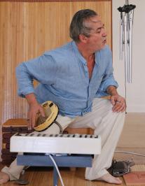 le conteur habillé en bleu et blanc avec des instruments de musique